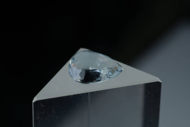 istock Natural blue aquamarine on a stand on a black background 1335431740