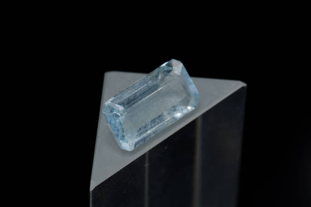 istock Natural blue aquamarine on a stand on a black background 1335431772