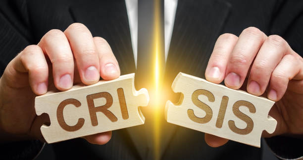 istock Man breaks two puzzles with word Crisis. Avoid or end economic political crisis. Recovery, overcoming consequences. New business and industry opportunities. Stabilization financial system 1335432507