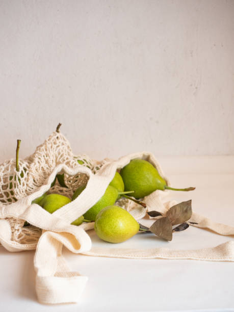 istock Ripe garden green pears in a light cotton string bag on a white background 1335432975