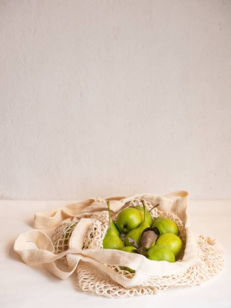 istock Ripe garden green pears in a light cotton string bag on a white background 1335433013