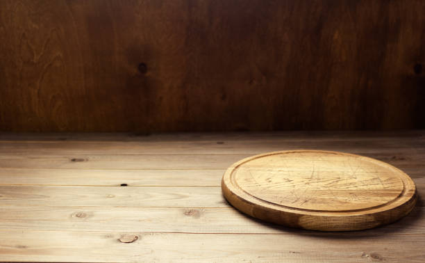 istock Pizza cutting board for homemade bread cooking or baking on table. Empty pizza board at wooden tabletop 1335434892