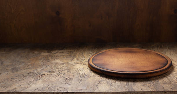 istock Pizza cutting board for homemade bread cooking or baking on table. Empty pizza board at wooden tabletop 1335434923