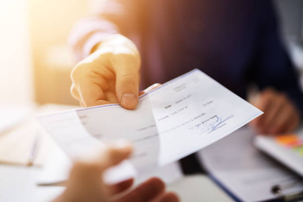 istock Businessperson Hands Giving Cheque 1335440152