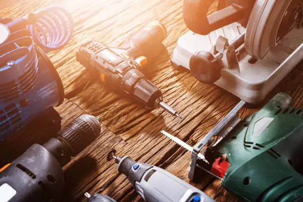 Various Power Tools Laying On Wooden Desk