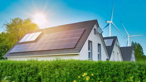 istock Solar panel on a house roof and wind turbines around - 1335442168
