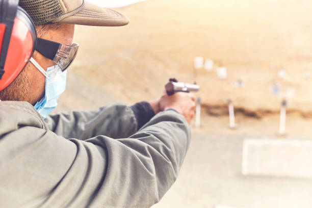 istock Man with hand gun aiming at shooting range and releasing stress. Selective Focus 1335443309