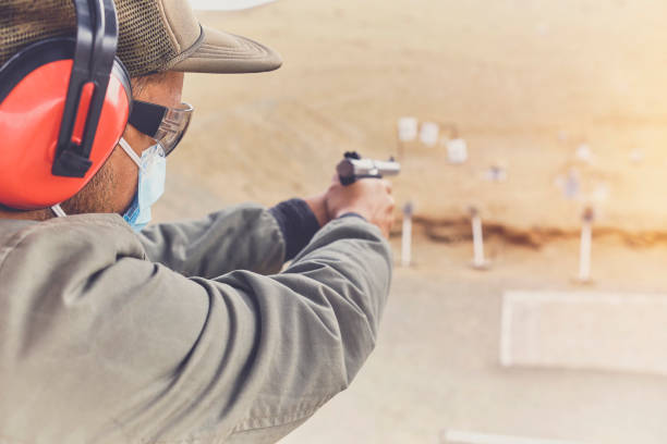 Man with hand gun aiming at shooting range and releasing stress. Selective Focus
