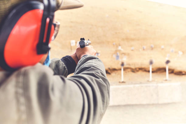 istock Man with hand gun aiming at shooting range and releasing stress. Selective Focus 1335443329