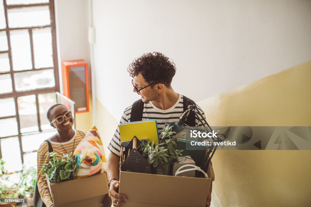 College students moving in dorm Flatmates moving in college dorm. They are caring boxes. Relocation Stock Photo