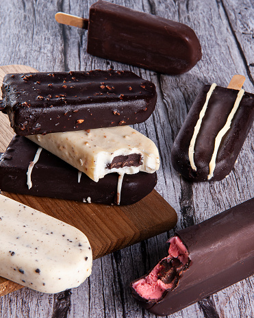 Composition with chocolate popsicles on wooden background. Top view