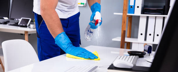 istock Janitor cleaning white desk in office 1335446686