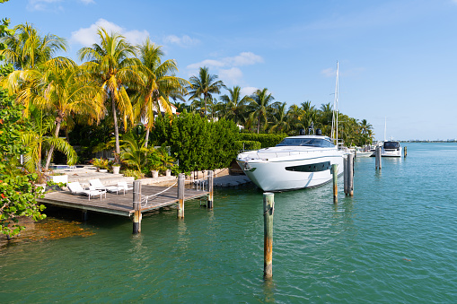 Luxury yacht boat docked at private mooring in tropical sea resort in Miami, USA.
