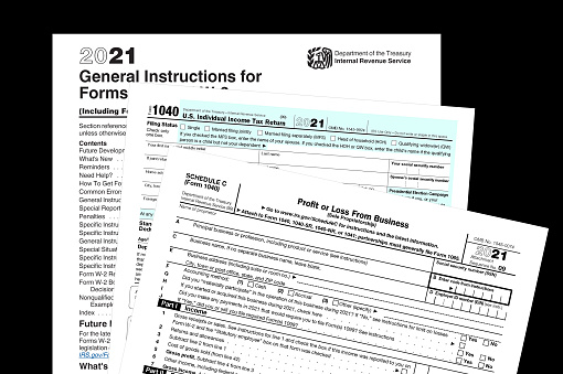 2021 IRS tax forms on a black desktop.