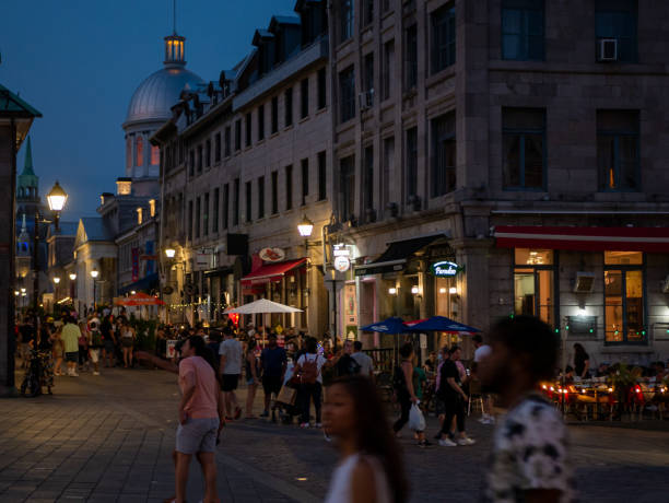 People walking in the Old Port of Montreal and Bonsecours Market at dusk stock photo