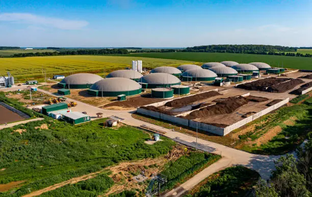 Biogas station at the green large field. Distillation process is used to produce bio gas at station. View from above