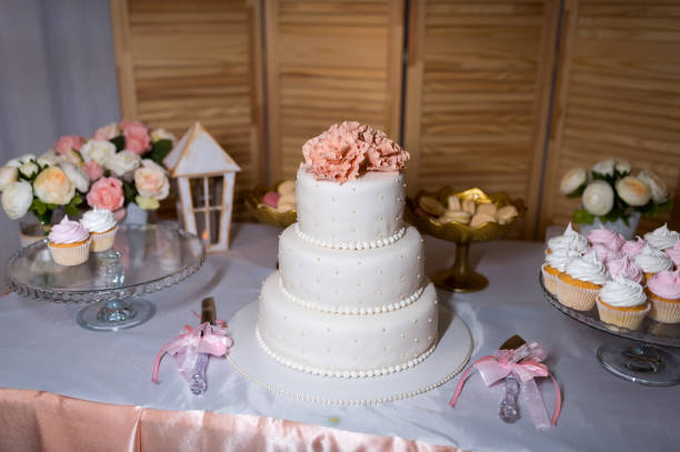 istock Delicious cookies on the wedding table for guests on the white tablecloth. Wedding cake, colorful cupcakes, confectionery buffet, sweets indoors 1335458715