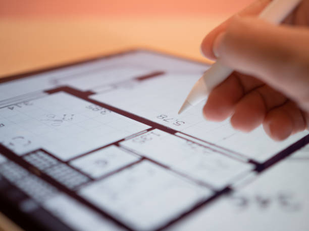 istock An architectural engineer is working on a floor plan of a building on a mobile 1335466780