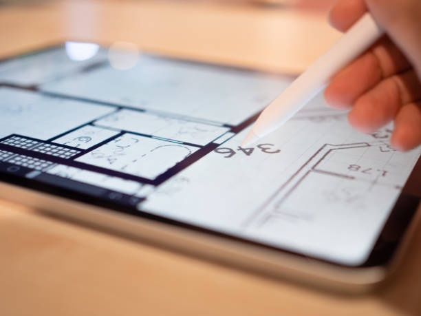istock Interior Designer is working on a floor plan of a building on a mobile 1335466784