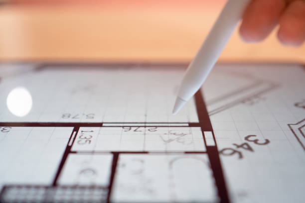 istock Interior Designer is working on a floor plan of a building on a mobile 1335466786
