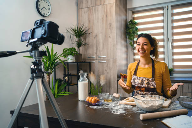 istock Woman filming vlog while kneading pastries at home in the kitchen 1335468377