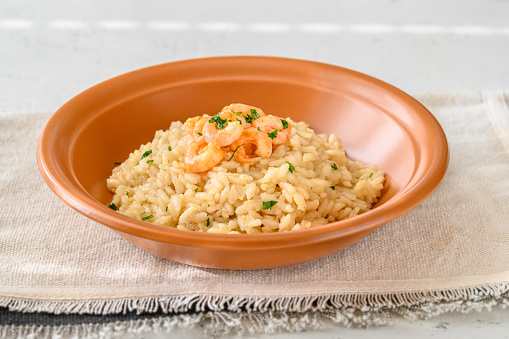 Portion of risotto garnished with prawn in the bowl