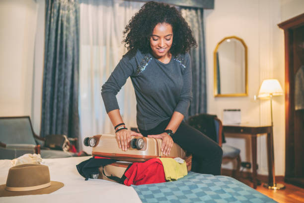 istock Woman struggling with overflowing suitcase 1335472033
