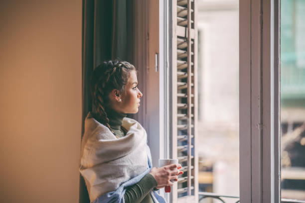 istock Woman looking out the window 1335472043