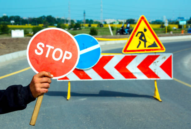 istock Worker holding a stop sign during road construction. Road construction on the highway. 1335472159