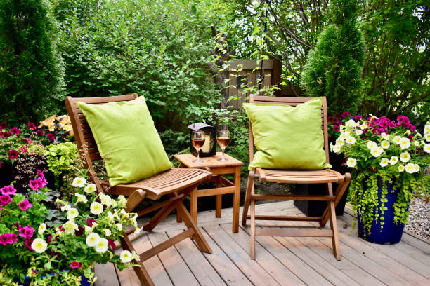 Sheltered outdoor garden patio oasis for afternoon backyard relaxation and glass of wine on warm seasonal summer days Garden cafe deck with seating for cozy seasonal evenings with beautifully designed flowering planters for lush natural luxury setting patio stock pictures, royalty-free photos & images