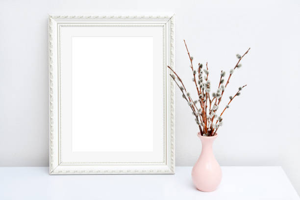 istock Pink vase with willow and white frame with copy space on a white table 1335475939