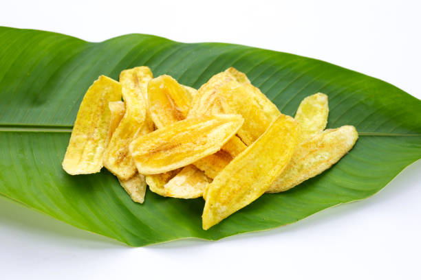 istock Banana slice chips on green leaves on white background 1335479694