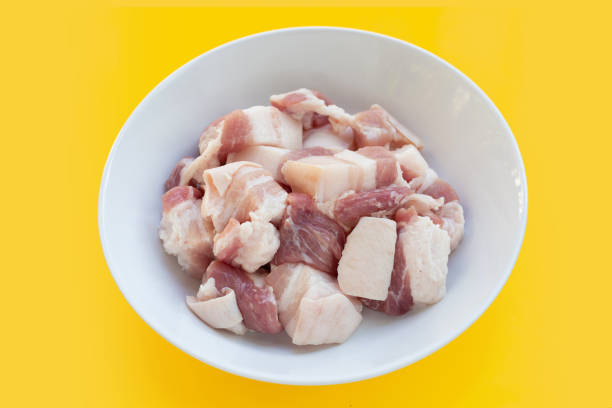 istock Cut streaky pork in white bowl on yellow background. 1335480721