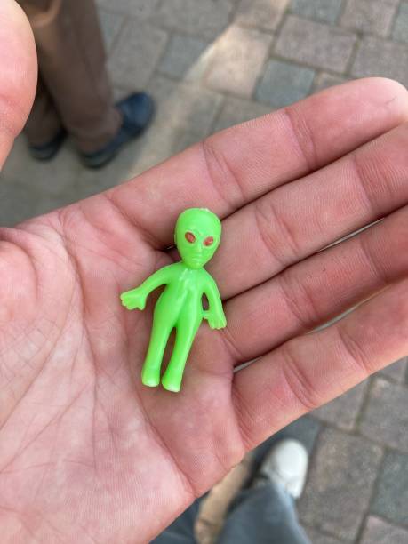 istock Small alien figurine in a adult hand. 1335481945
