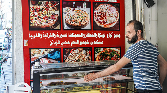 A Syrian immigrant that owns a fast food restaurant in Basmane Street poses in front of his shop in Izmir, in Turkey on August 18, 2021