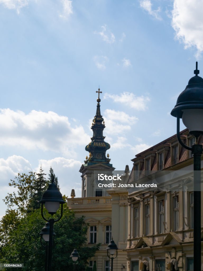 The clock tower of the Cathedral Church of St. Michael the Archangel , Belgrade. The clock tower of the Cathedral Church of St. Michael the Archangel with some ornamented buildings in the foreground. Belgrade, Serbia. Archangel Michael Stock Photo
