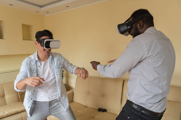 istock Cheerful Man and his African Friend are Browsing a Virtual World with Virtual Reality Goggles. 1335487873