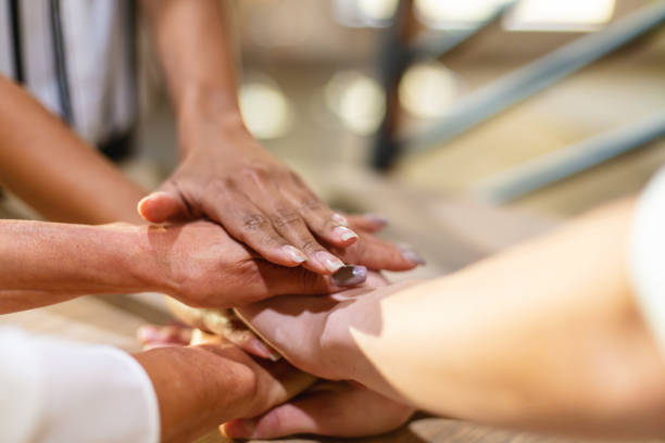 istock Multi Ethnic and Multi Generation  Group of Stacked Human Hands on Wood Table Displaying Teamwork and Unity Top Photo Series 1335488762