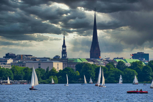 Sailboats on the lake, church towers and grey, cloudy sky in the background