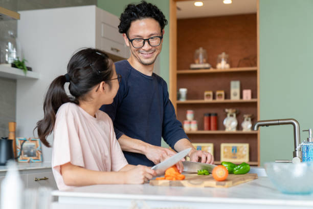 istock Father and daughter cutting vegetables together 1335497266