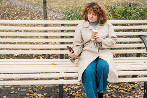 istock mobile communication autumn day woman phone bench 1335499766