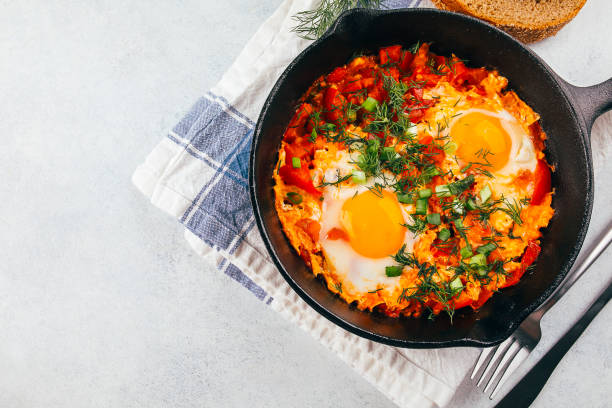 istock Traditional israel dish. Eggs with tomatoes. Dish Shakshouka in a pan on light table. Top view, copy space 1335500215