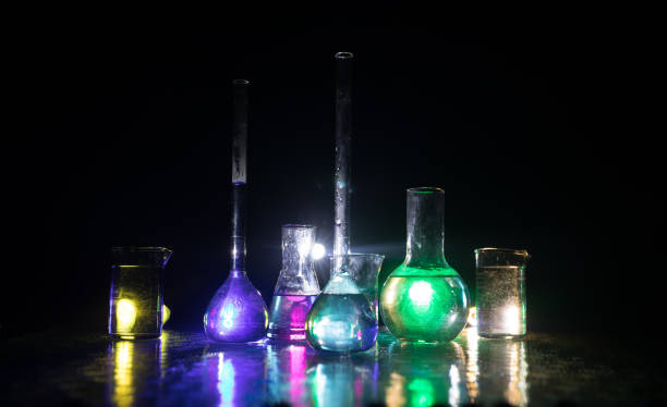 istock Test glass flask with solution in research laboratory. Science and medical background. Laboratory test tubes on dark toned background , science research equipment concept 1335502853