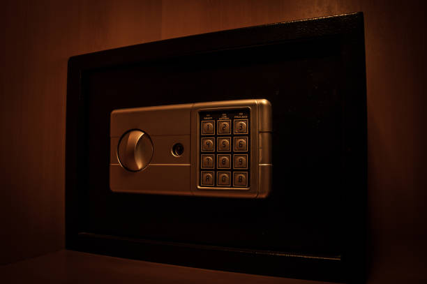 istock Small modern safe on shelf in dark. Small safe box close up in low key light 1335502854