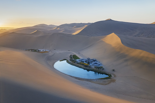 beautiful crescent lake and singing sands mountain in sunrise, famous tourist destination on the silk road, Dunhuang city, Gansu province, China.