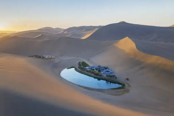 beautiful crescent lake and singing sands mountain in sunrise, famous tourist destination on the silk road, Dunhuang city, Gansu province, China.