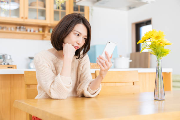 istock attractive asian woman to see a smart phone,think, 1335507581