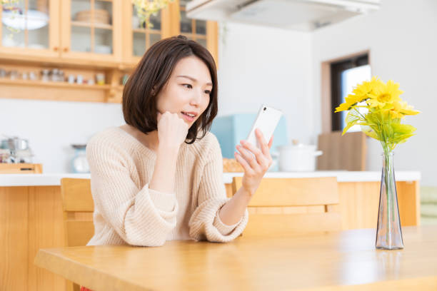 istock attractive asian woman to see a smart phone,think, 1335507619