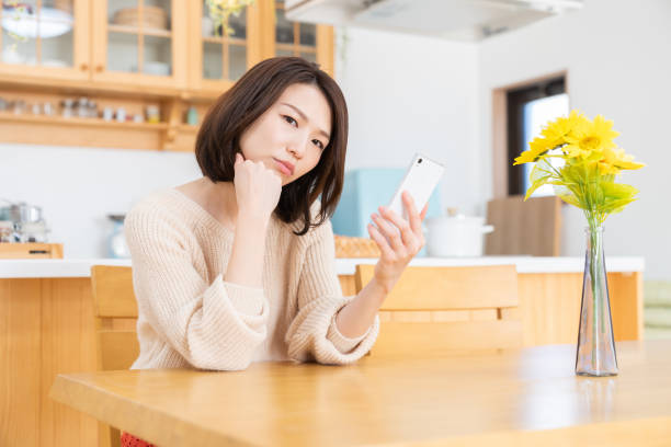 istock attractive asian woman to see a smart phone,think, 1335507723