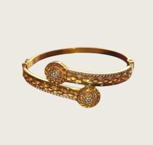 Fancy gold bracelet with diamonds isolated on cream color